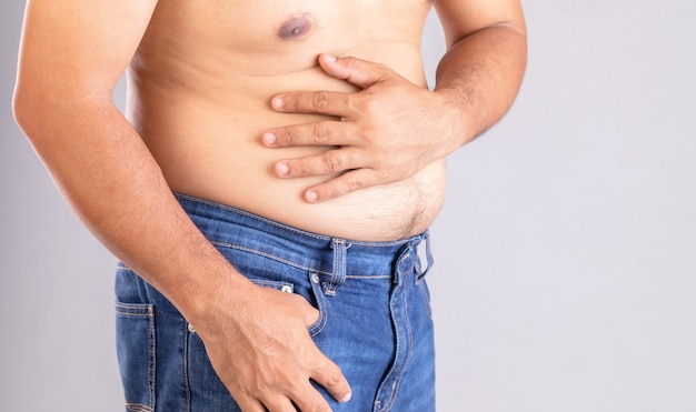 Maux d'estomac ou douleur sur le concept du ventre: gros homme utilisant sa main et en appuyant sur l'estomac