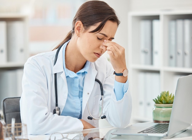 Maux de tête douleur médecin stress et épuisement dû au travail à l'hôpital sur ordinateur portable triste à propos d'un problème de santé mentale et d'anxiété travaillant dans les soins de santé Infirmière médicale fatiguée souffrant de dépression et d'erreur à la clinique