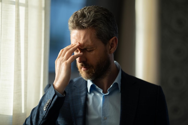 Maux de tête fatigue et stress portrait d'homme en costume a des maux de tête migraine douleur c