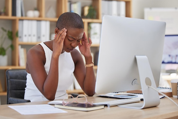 Maux de tête migraine et douleur d'une femme à l'ordinateur stress dépression ou risque pour la santé mentale au bureau pour les nouvelles Homme d'affaires africain confus déprimé ou frustré souffrant d'épuisement professionnel ou de fatigue en ligne