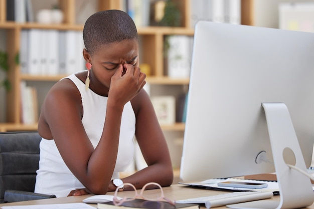 Maux de tête migraine et femme triste sur ordinateur stress dépression ou risque pour la santé mentale au bureau pour les nouvelles Douleur déprimée ou en colère Homme d'affaires africain souffrant d'épuisement professionnel ou de fatigue pour une carrière en ligne