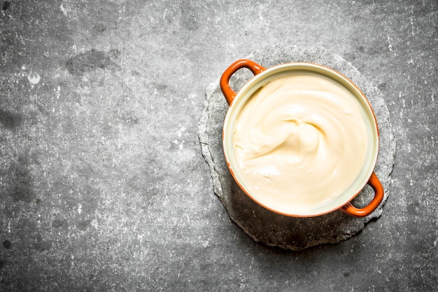 Mayonnaise dans un bol. Sur la table en pierre.