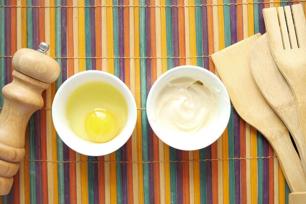 Mayonnaise dans de l'huile de récipient et des œufs sur la table