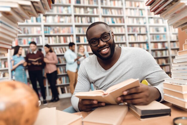 Mec afro-américain assis à table.