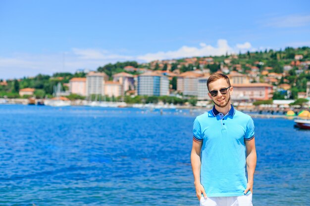 Mec barbu à lunettes de soleil tenir les mains dans les poches et sourire