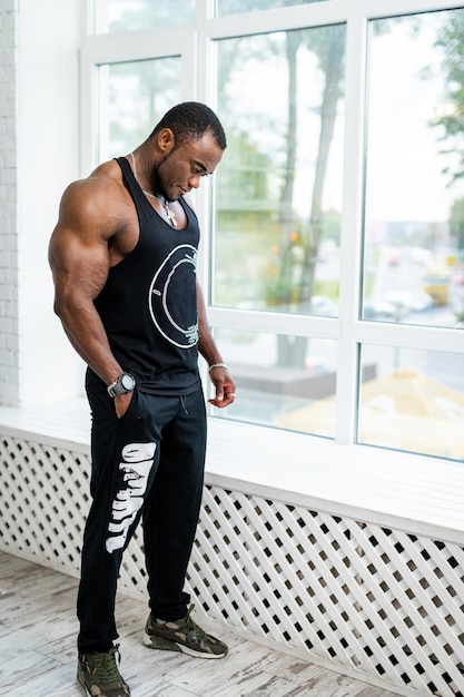 Mec bodybuilder avec des muscles énormes Bel homme musclé posant devant la caméra avec des bras parfaits