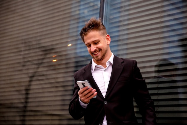 Un mec en costume regarde le téléphone avec émotion