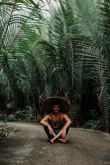 mec dans un chapeau de paille dans un environnement tropical