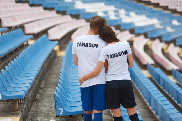 Mec émotionnel Et Fille Embrasse Sur Le Stade. élégant Jeune Couple Embrassant Un Stade