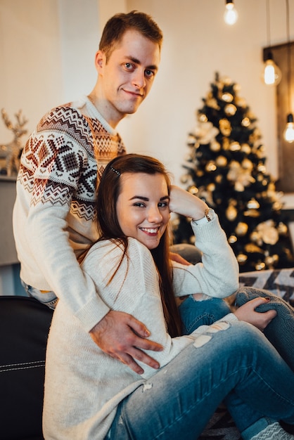 Un mec et une femme fêtent Noël ensemble dans une ambiance chaleureuse