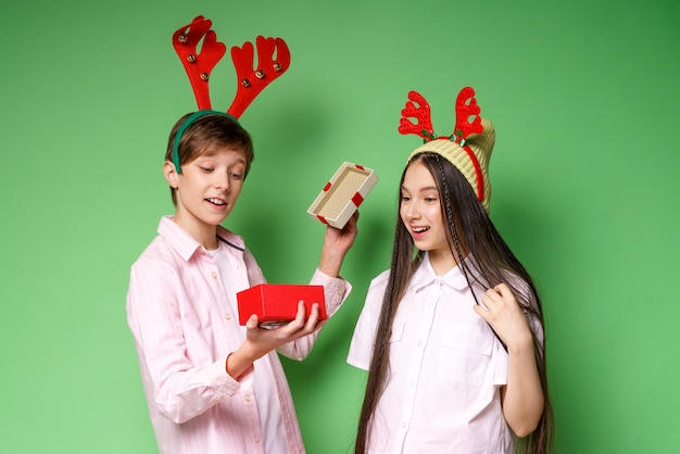 Mec et fille mignons avec des cornes de cerf sur la tête une petite boîte cadeau ouverte avec des décorations d'un mec avec ...