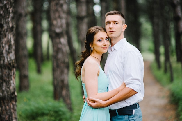 Un Mec Heureux En Chemise Blanche Et Une Femme En Robe Turquoise Marchent Dans Le Parc Forestier