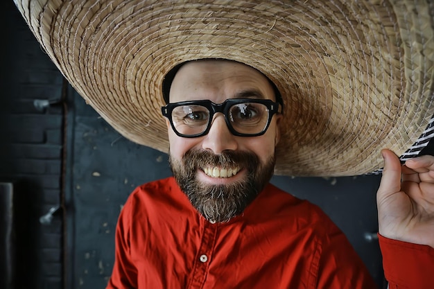 mec hipster à lunettes avec une barbe grise dans un chapeau à bord. homme modèle posant émotionnellement