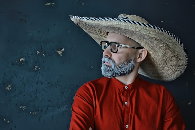 mec hipster à lunettes avec une barbe grise dans un chapeau à bord. homme modèle posant émotionnellement