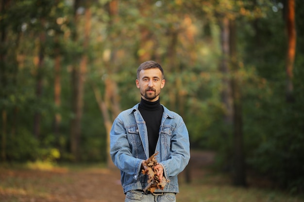 Le mec jette les feuilles Un mec en promenade à l'automne Un mec heureux Un homme se promène dans le parc