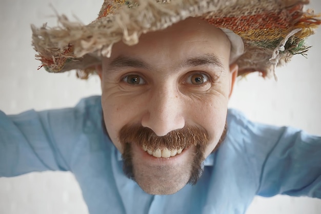 mec joyeux avec une moustache dans un chapeau de paille