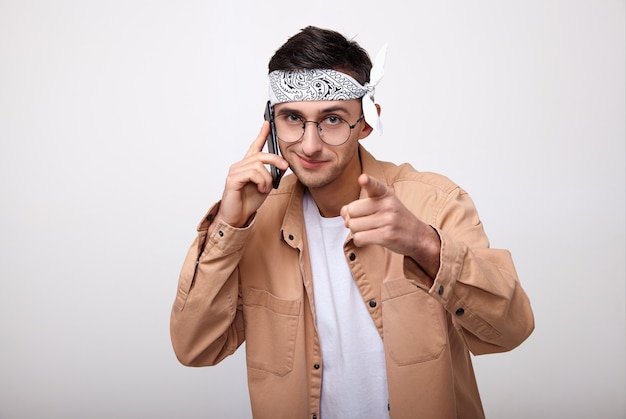 Le mec à la mode a l'air droit et parle au téléphone.