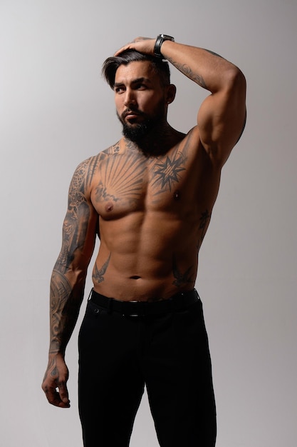 Mec musclé tatoué torse nu en studio