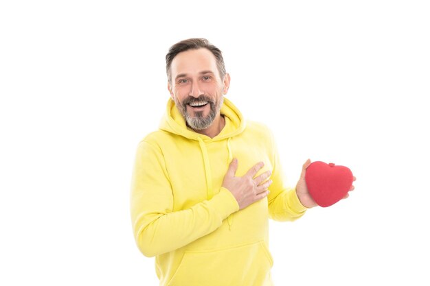 Un mec senior souriant tient un présent isolé sur un homme blanc en sweat à capuche jaune adulte saint valentin tient un concept de don de cadeau romantique symbole d'amour saint valentin mature homme heureux avec une boîte en forme de coeur