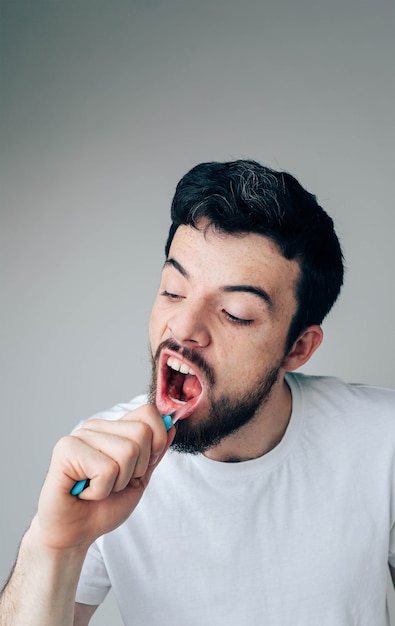 Mec sérieux travailleur nettoyant les dents avec une brosse à dents.