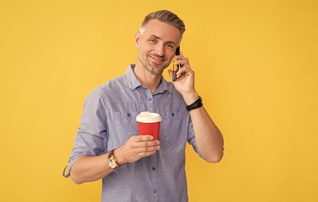 Un mec souriant boit du thé à emporter bonne communication du matin