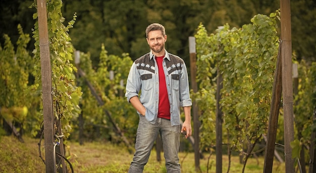 Un mec souriant debout avec des ciseaux de jardin à la récolte d'été de la cave