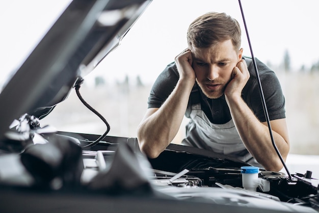 Mécanicien automobile au service de voiture vérifiant la voiture