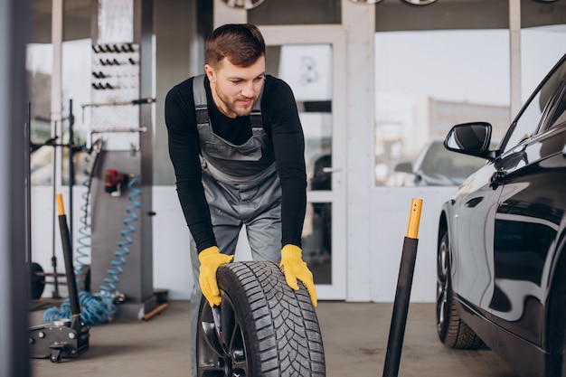 Mécanicien automobile changeant les roues en voiture