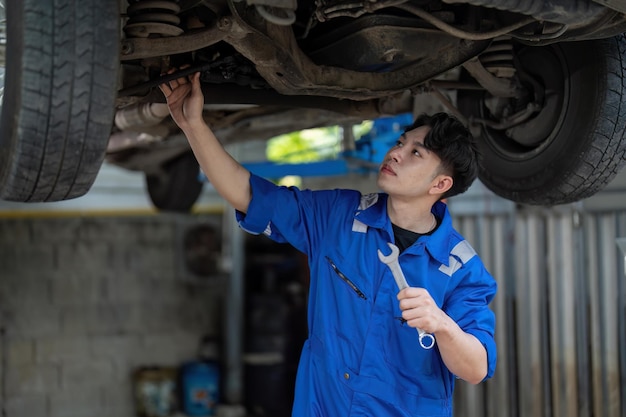 Mécanicien automobile détail de la suspension de voiture de l'automobile soulevée à la station-service de réparation