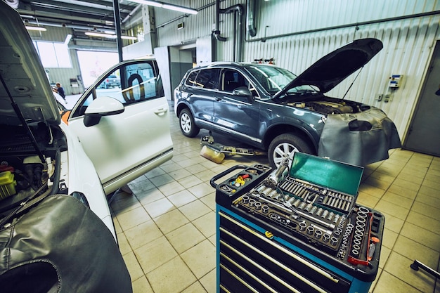 Mécanicien automobile regardant le moteur pour analyser les symptômes de la voiture à la station-service de réparation d'entretien.