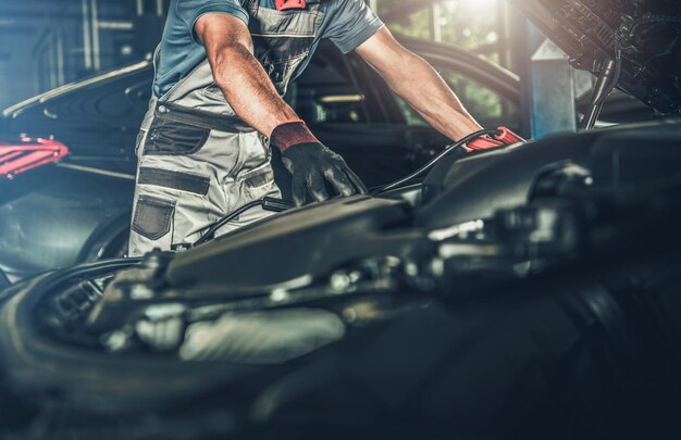 Photo mécanicien automobile regardant sous le capot du véhicule