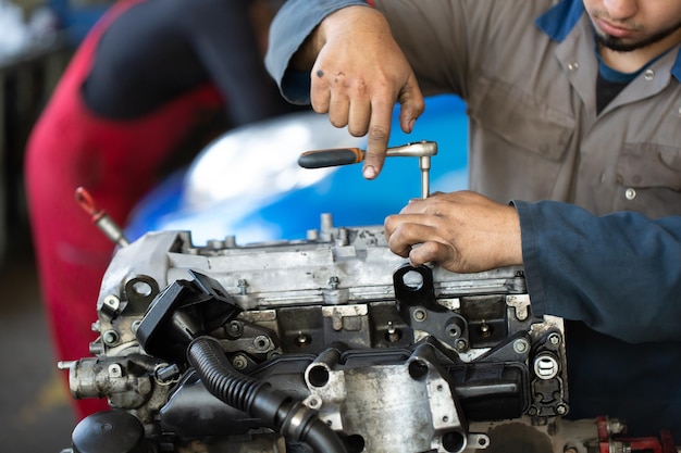 Un mécanicien automobile répare un moteur à combustion interne.