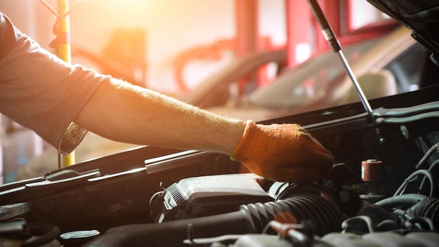 Un mécanicien automobile répare un moteur de voiture un service de voiture un atelier de réparation automobile