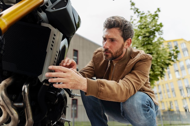 Un mécanicien automobile répare une roue de moto dans la rue.