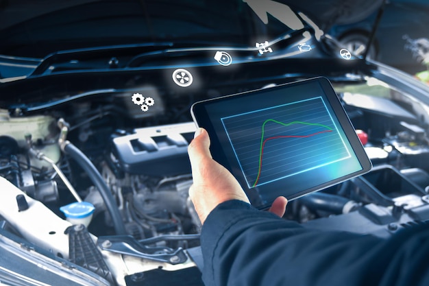 Le mécanicien automobile vérifie le système moteur avec une tablette ODB2 et un concept d'entreprise d'atelier de réparation automobile iconauto service