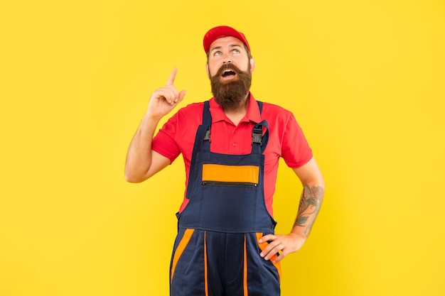 Mécanicien barbu inspiré en vêtements de travail sur fond jaune