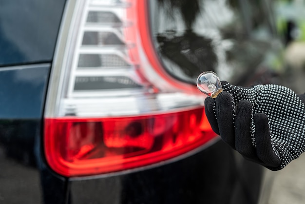 Mécanicien changeant l'ampoule dans sa voiture. La technologie