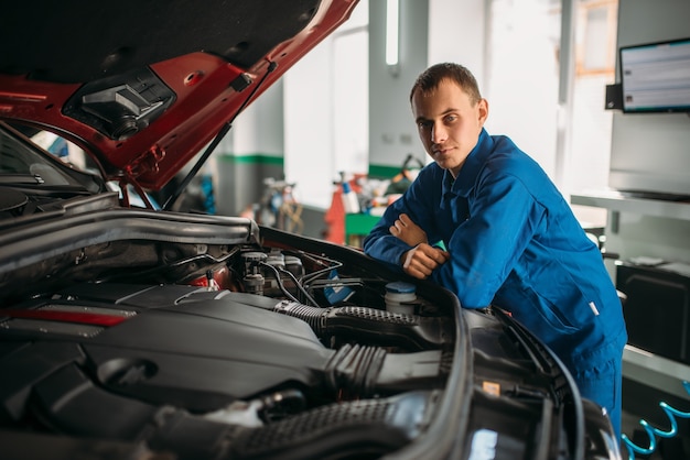 Le mécanicien effectue une inspection visuelle du moteur de la voiture