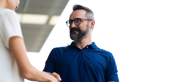 Mécanicien d'expertise serrant la main d'un client satisfait et travaillant dans le garage de la station de maintenance de réparation automobile. Satisfaction au service.