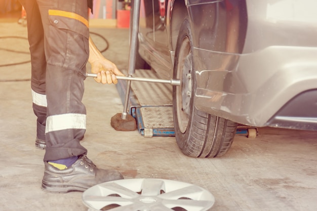 Mécanicien fixant le dispositif d&#39;alignement de roue sur une roue de voiture d&#39;un pneu neuf