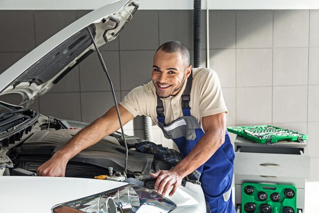 Photo mécanicien mécanicien automobile expertise travail bonnet examinant à la