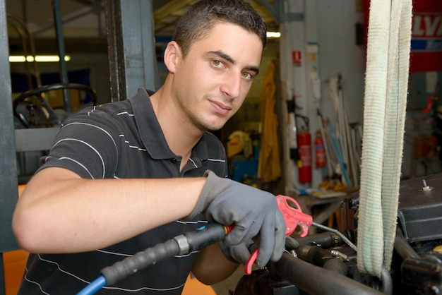 Le mécanicien nettoie le moteur à l'air comprimé