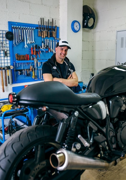 Photo mécanicien posant avec une moto