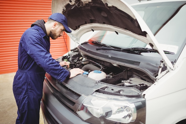 Mécanicien réparant le moteur d'une camionnette