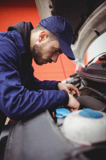 Photo mécanicien réparant le moteur d'une camionnette