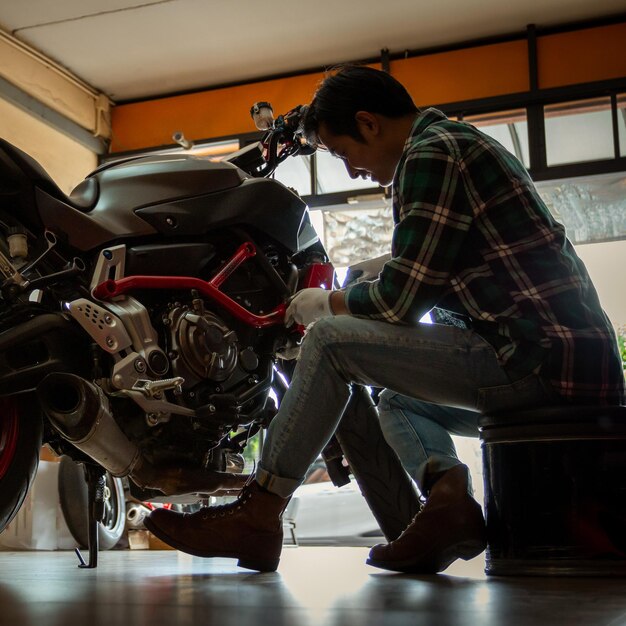 Photo mécanicien réparant une moto au garage