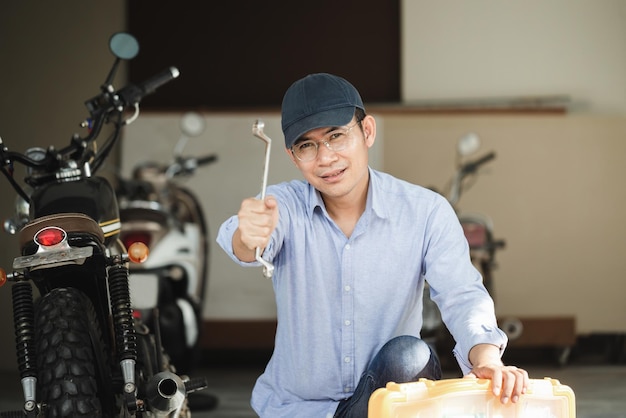 Mécanicien réparant une moto dans un garage d'atelier Homme réparant une moto dans un atelier de réparation Concepts de réparation et d'entretien