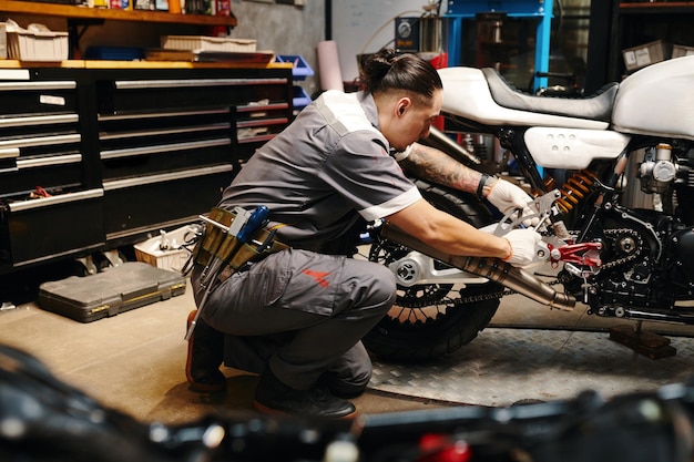 Un mécanicien répare une moto dans le garage.