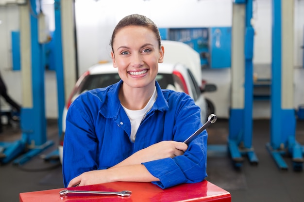 Mécanicien souriant à la caméra du garage de réparation