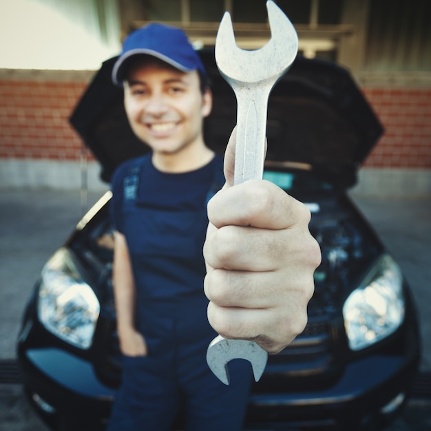 Mécanicien tenant une clé dans un garage